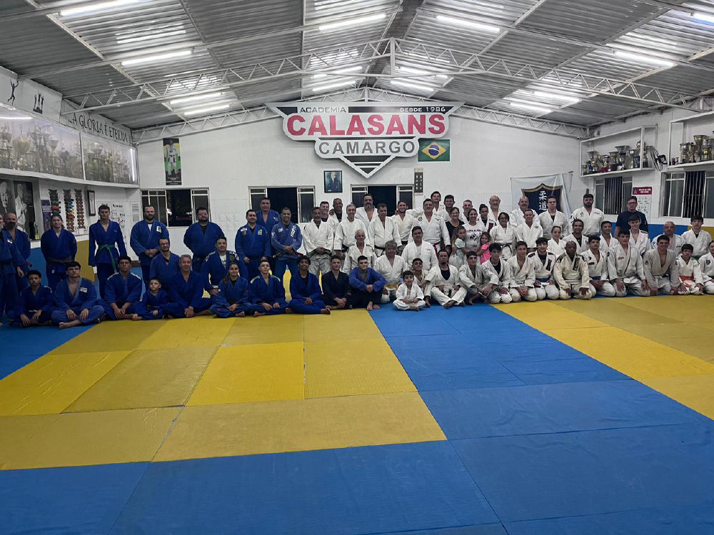 Grande grupo de alunos e professores no tatame da Academia Calasans Camargo